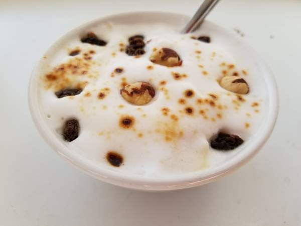 Oatmeal with Frothed Milk, Jaggery, Raisins, & Hazelnuts